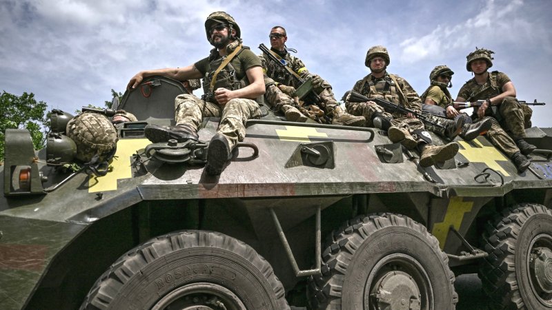 Ukrainian troops sit on an armoured vehicle as they move back from the front line near the city of Sloviansk in the eastern Ukrainian region of Donbas on June 1, 2022.