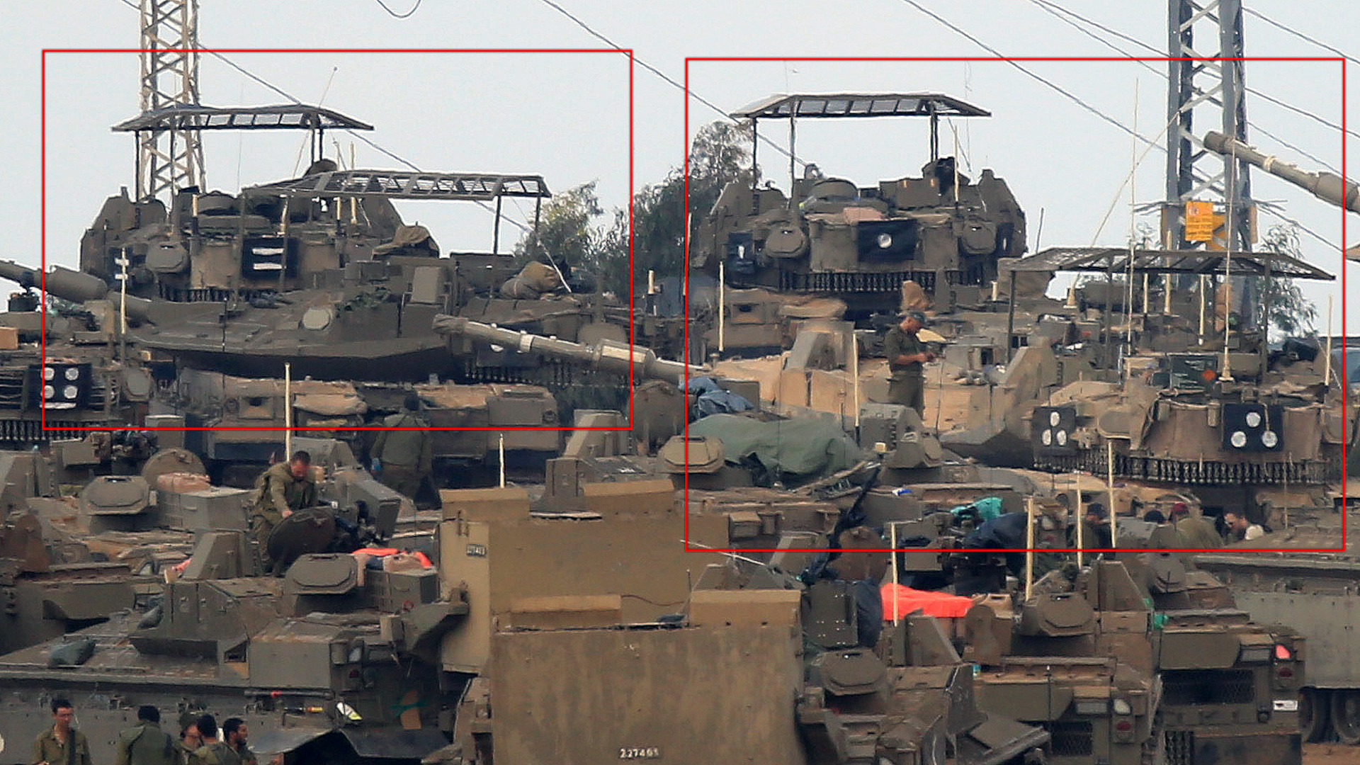 Israeli Merkava tanks, some with "cope cage" style armor screens on top of their turrets, mass near Gaza.