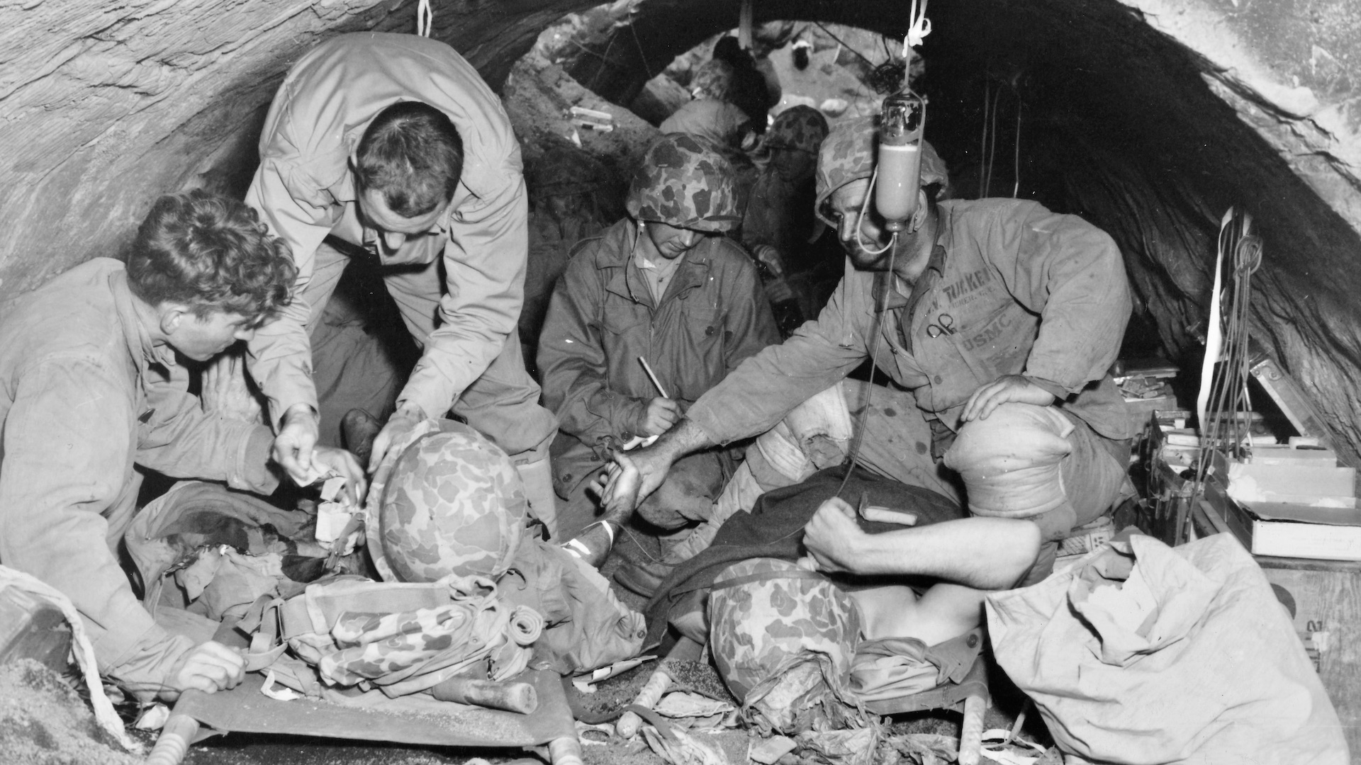 Marines, wounded in the battle for Iwo Jima, are sheltered in a Japanese concrete air raid shelter which was not completely destroyed in the three-day bombardment and aerial attack preceding the landing.