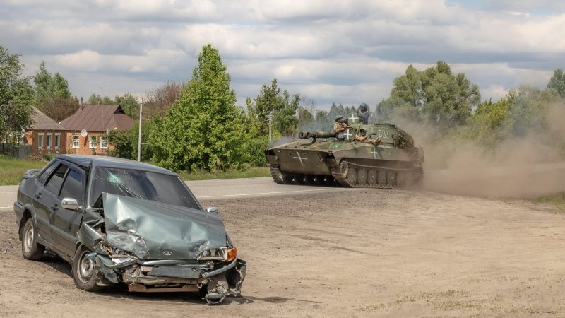 A Ukrainian self-propelled howitzer 2S1 Gvozdika drives past a damaged car on a road in the Vovchansk district, Kharkiv region, on May 12, 2024, amid the Russian invasion of Ukraine. Thousands of people have been evacuated from border areas in Ukraine's Kharkiv region, as Russia kept up constant strikes on a key town as part of a cross-border offensive, officials said on May 12, 2024. The surprise Russian attack across Ukraine's northeastern border began on Friday, with troops making small advances in an area from where they had been pushed back nearly two years ago.