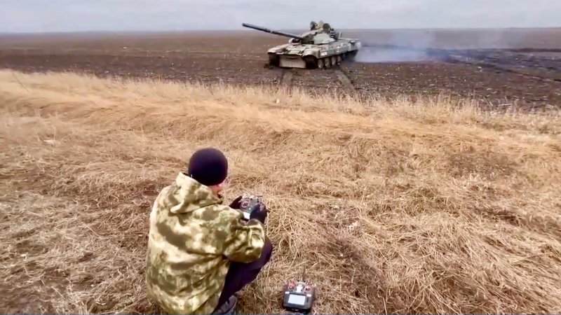 A Russian operative controls a captured Ukrainian tank via remote controls.