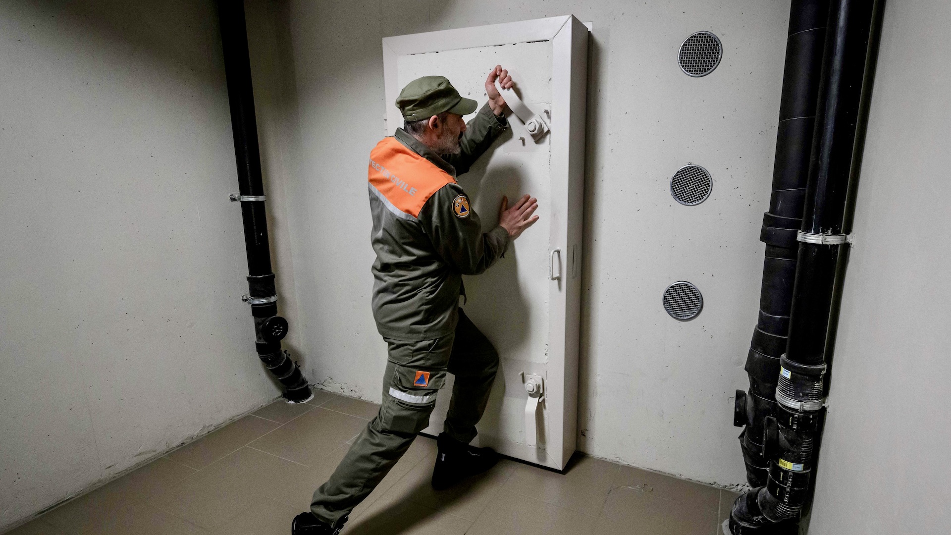 An officer of the Swiss Civil defence of the canton of Geneva closes the door of a private concrete nuclear fallout shelter located underneath a residential building in the city of Meyrin near Geneva on March 25, 2022. - Russia's invasion of Ukraine has awakened long-slumbering anxiety interest in Switzerland in concrete nuclear fallout shelters built across the country during the Cold War, with spots available for every single resident. (Photo by Fabrice COFFRINI / AFP) (Photo by FABRICE COFFRINI/AFP via Getty Images)