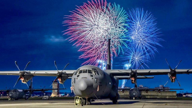A C-130J Super Hercules rests on the flightline under a fireworks display, July 3, 2018, at Yokota Air Base, Japan.