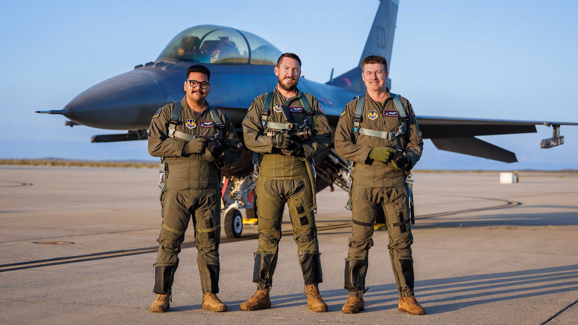 412th Test Wing photographers Christian Turner, Todd Schannuth, and Richard Gonzales on the ramp with their F-16D chase jet.