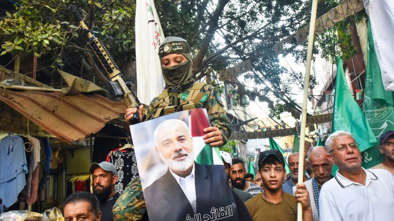 Demonstrators wave flags and hold pictures of the leader of the Palestinian militant Hamas group, Ismail Haniyeh, (C) and senior leader Saleh al-Arouri during a protest on July 31, 2024 in Beirut's Burj al-Barajneh camp for Palestinian refugees, denouncing his killing. Hamas said on July 31 its political leader Ismail Haniyeh was killed in an Israeli strike in Iran, where he was attending the swearing-in of the new president, and vowed the act "will not go unanswered".