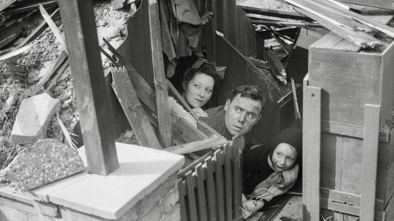 The Dallison family leave their Anderson shelter to view the wreckage caused by a nearby bomb explosion the night before, January 1, 1940. Photo by Keystone Features/Getty Images.