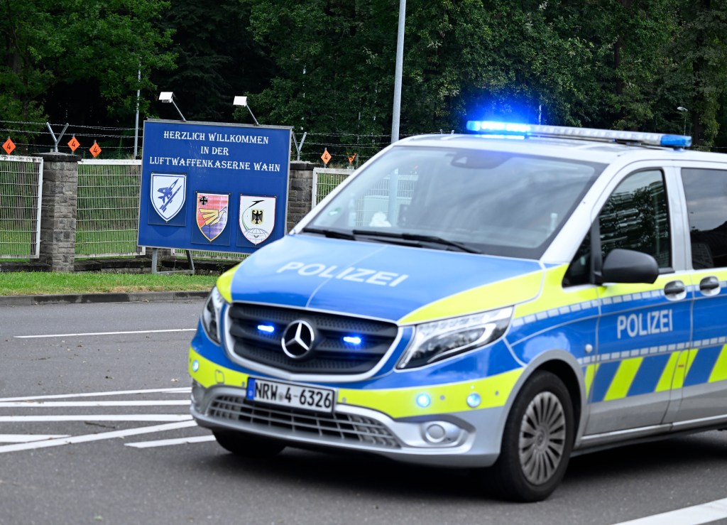 dpatop - 14 August 2024, North Rhine-Westphalia, Cologne: A police car stands in front of the entrance to the air force barracks in Wahn. The barracks have been cordoned off. Photo: Roberto Pfeil/dpa (Photo by Roberto Pfeil/picture alliance via Getty Images)