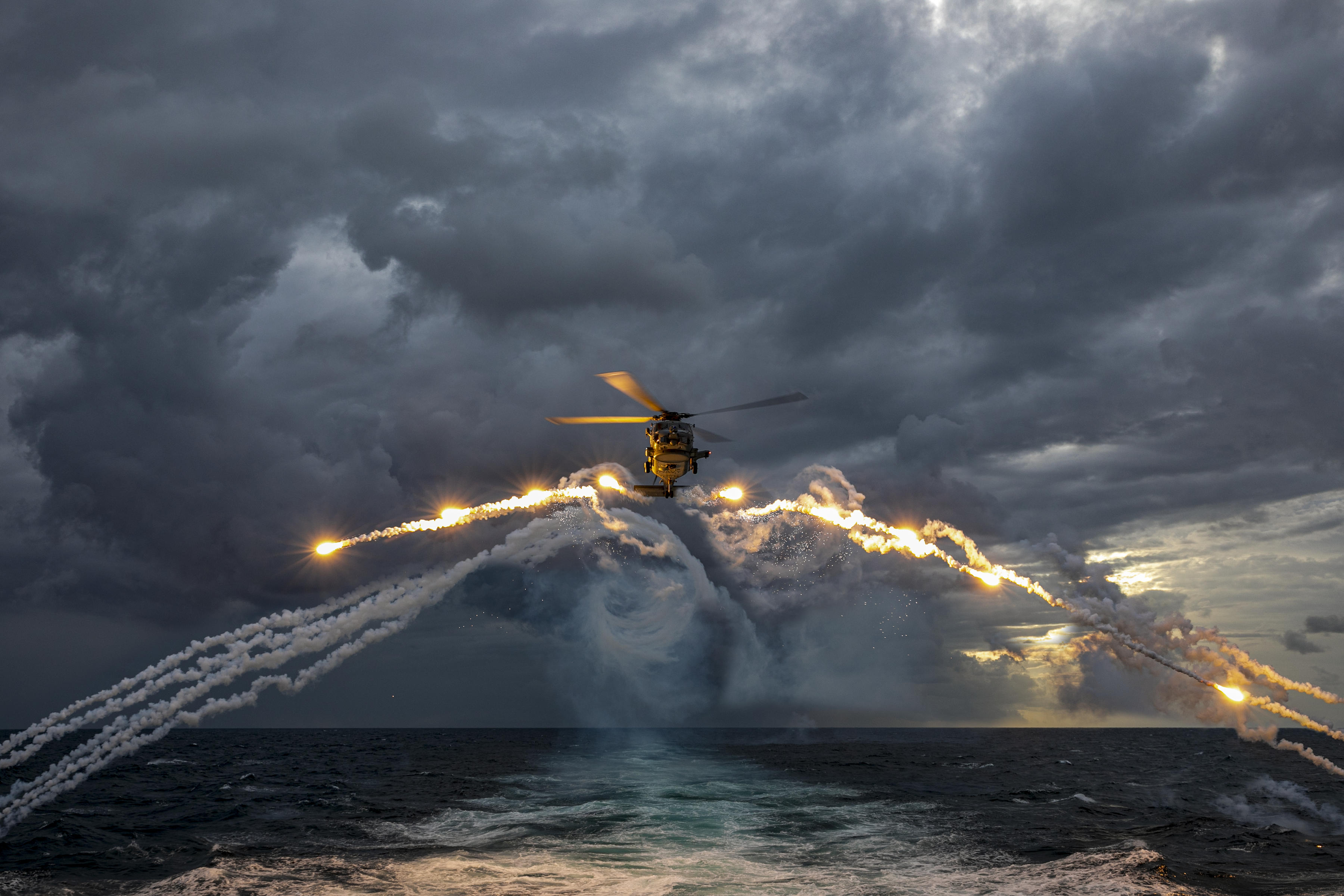 An MH-60R Seahawk helicopter embarked on HMAS Parramatta deploys Counter Measure Dispense System flares during a training flight conducted on a deployment through South East Asia. *** Local Caption *** Royal Australian Navy Helicopter Frigate HMAS Parramatta has returned to Australia after completing a three-month deployment incorporating South and South East Asia. The deployment showed Australia's commitment to our partners and to a secure and prosperous region.