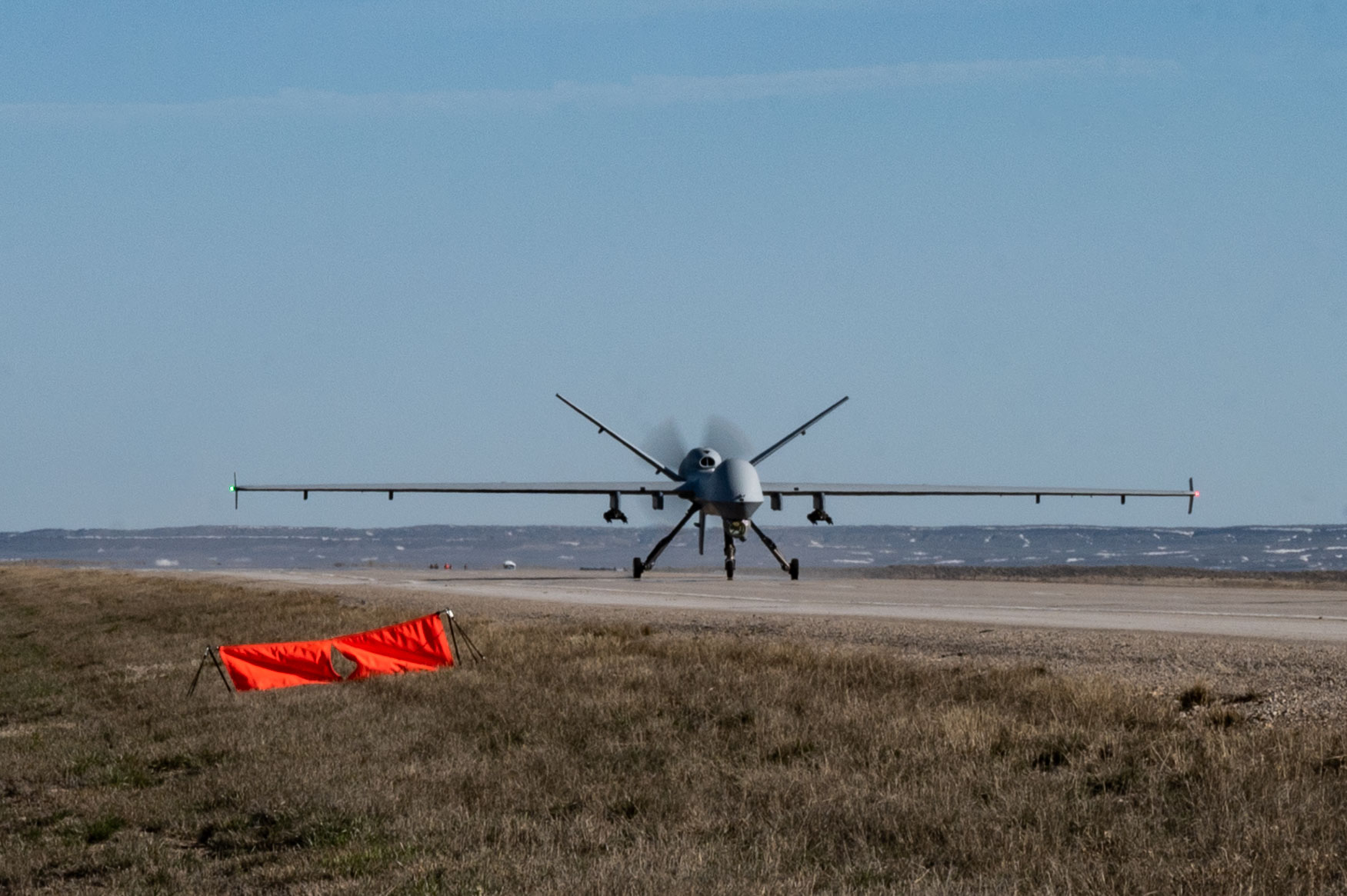 An MQ-9 Reaper lands on Highway 287 during Exercise Agile Chariot, April 30, 2023, honing capabilities linked to Agile Combat Employment. Instead of relying on large, fixed bases and infrastructure, ACE uses smaller, more dispersed locations and teams to rapidly move and support aircraft, pilots, and other personnel to wherever they are needed. There are millions of miles of public roads in the United States, including federal, state, and local roads – with Agile Combat Employment, including Forward Arming and Refueling Point (FARP) and Integrated Combat Turnarounds (ICT), it can become millions of miles of public runways, when necessary. (U.S. Air Force photo by Tech. Sgt. Carly Kavish)