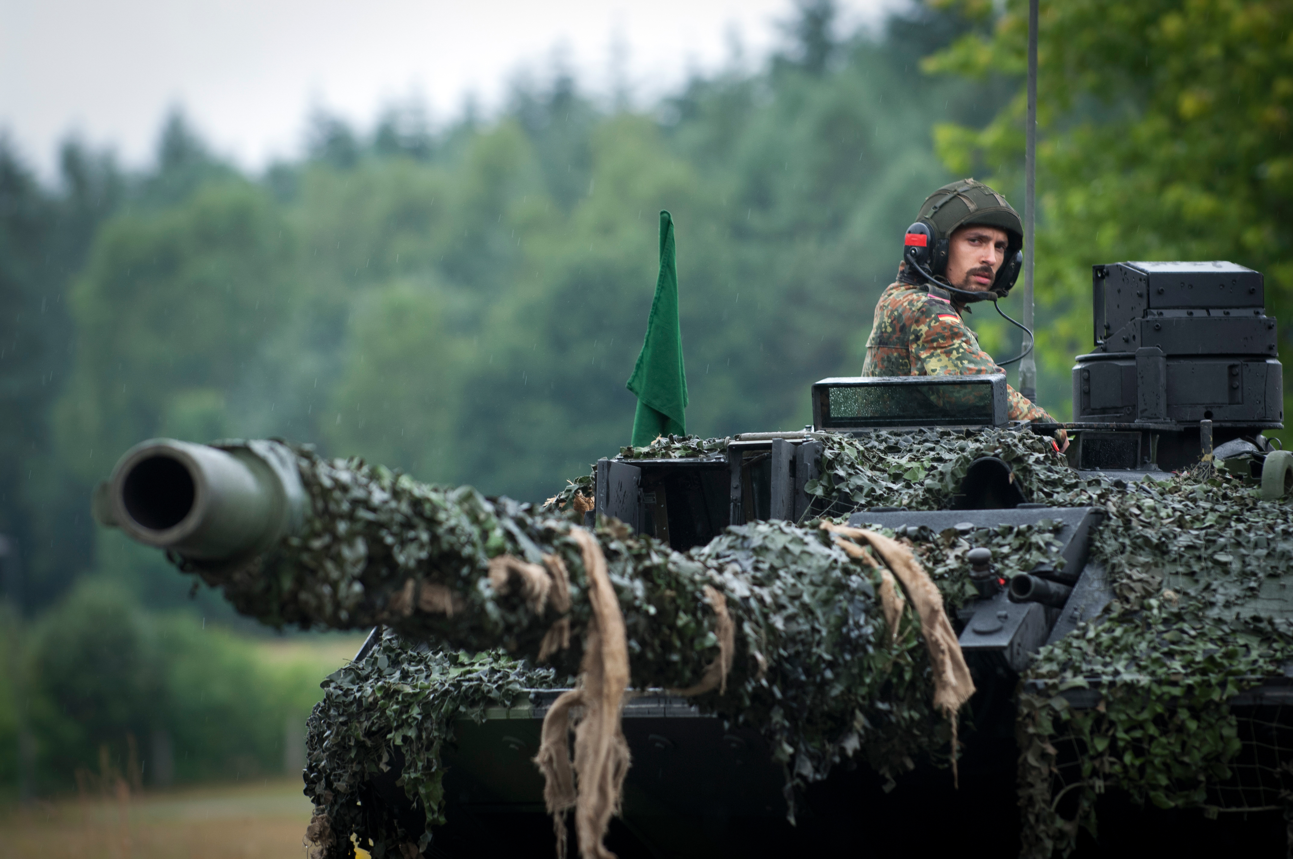 BERGEN-LOHHEIDE, GERMANY - JUNE 21: A Soldier commanding his tank crew from the open turret of a Leopard 2 A6MA2 main battle tank at the Panzerbattalion 414 firing grounds on Lueneburg Heath, Bergen-Lohheide, Lower Saxony, Germany on June 21, 2018. Panzerbattalion 414 (Tank Battalion 414) is Europe's first integrated Battalion made up of Soldiers from 2 nations-Germany and Netherlands. The mixed Battalion of Dutch and German armies, Bundeswehr and Landmacht, operate as mixed crews and is officially part of the Bundeswehr (German Army). One in four out of 400 soldiers in Panzerbattalion 414 are Dutch from the Royal Netherlands Army. (Photo by Craig Stennett/Getty Images)