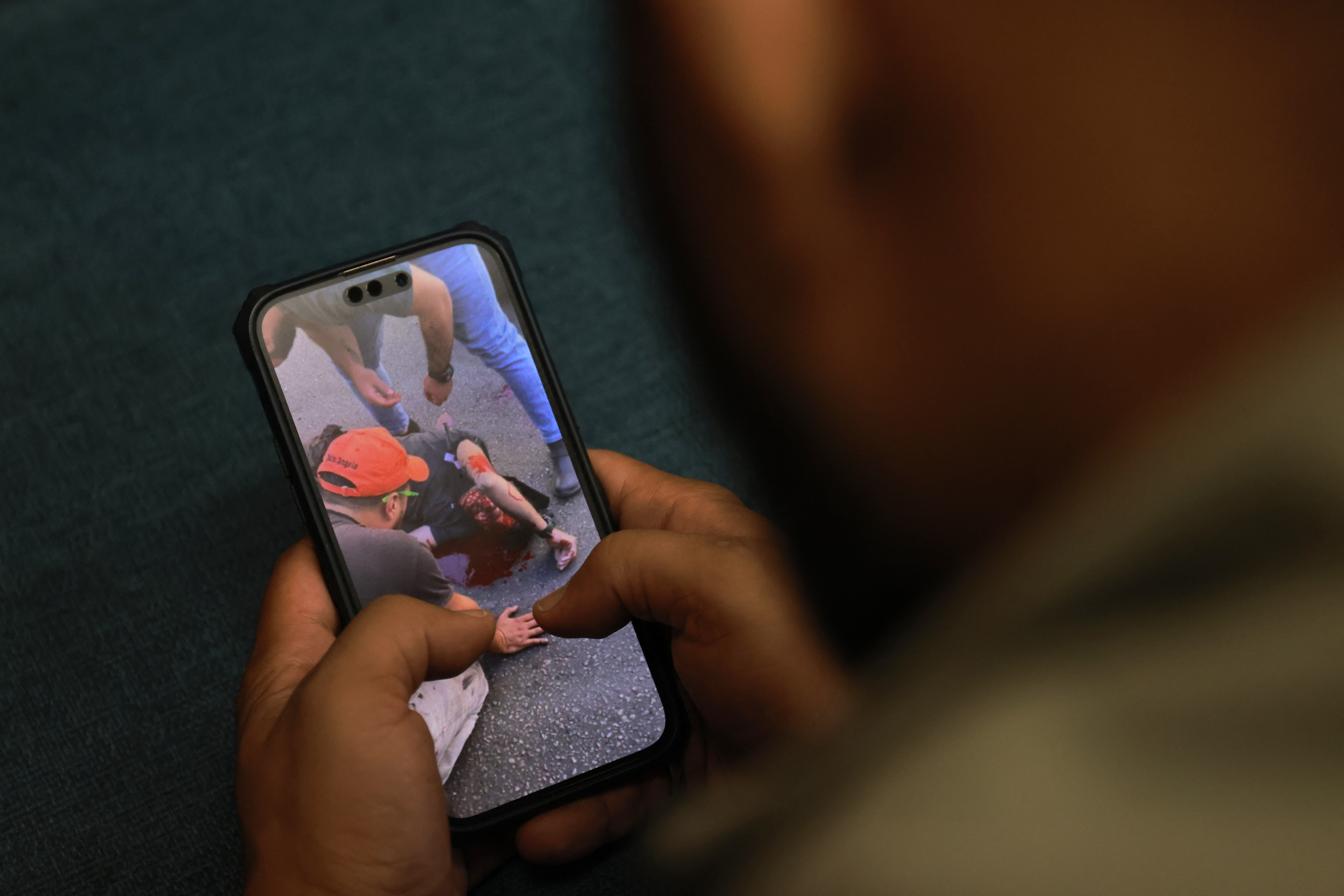 A man watches a video, published on social media, showing a wounded man on September 17, 2024, after explosions hit locations in several Hezbollah strongholds around Lebanon amid ongoing cross-border tensions between Israel and Hezbollah fighters. Hundreds of people were wounded when Hezbollah members' paging devices exploded simultaneously across Lebanon on September 17, in what a source close to the militant movement said was an "Israeli breach" of its communications. (Photo by JOSEPH EID / AFP) (Photo by JOSEPH EID/AFP via Getty Images)