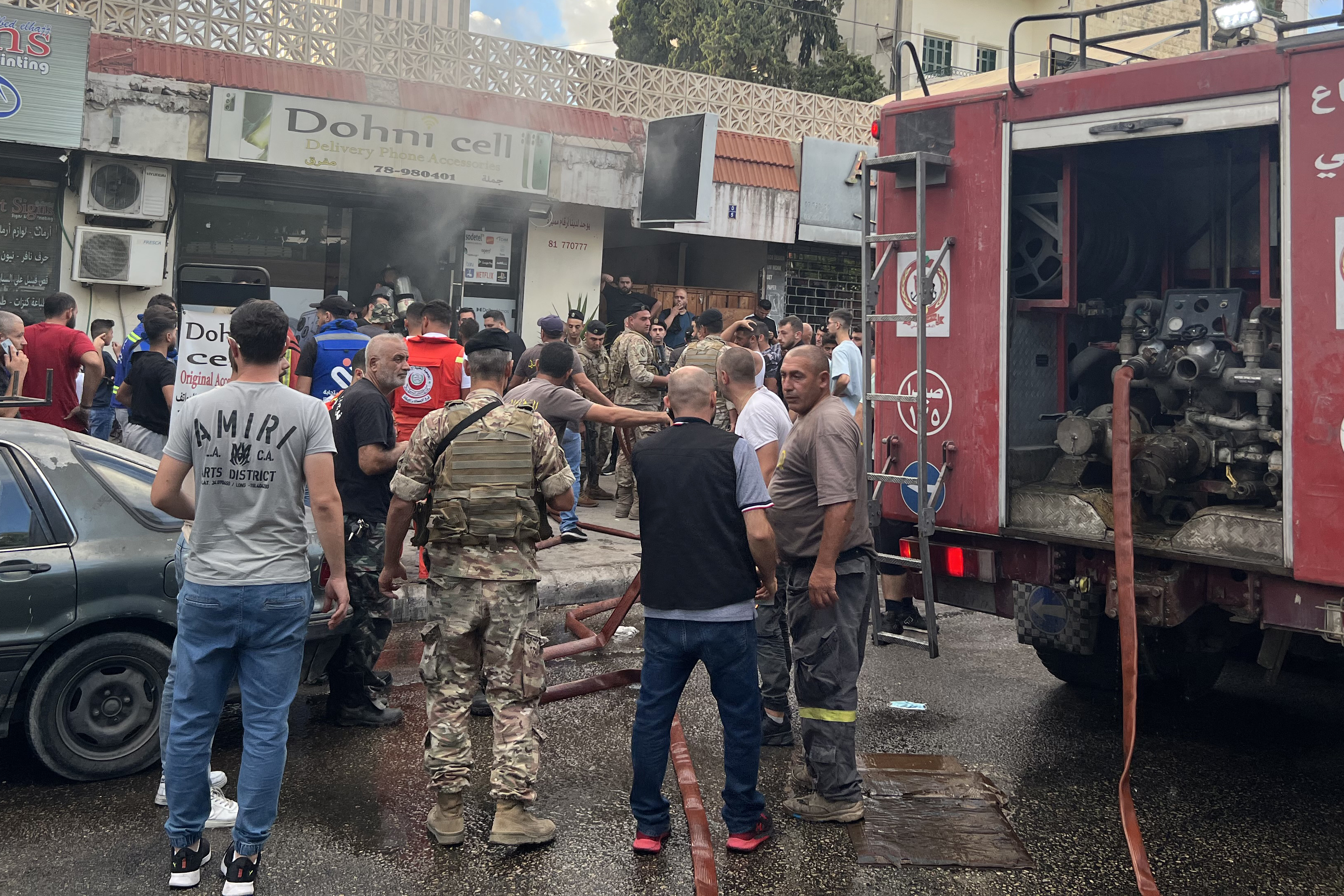 People and first responders gather at the scene of a reported device explosion in Saida in southern Lebanon on September 18, 2024. A second wave of device explosions killed three people in Hezbollah strongholds of Lebanon on September 18, raising fears of an all-out war between Israel and the Iran-backed militants. (Photo by Mahmoud ZAYYAT / AFP) (Photo by MAHMOUD ZAYYAT/AFP via Getty Images)