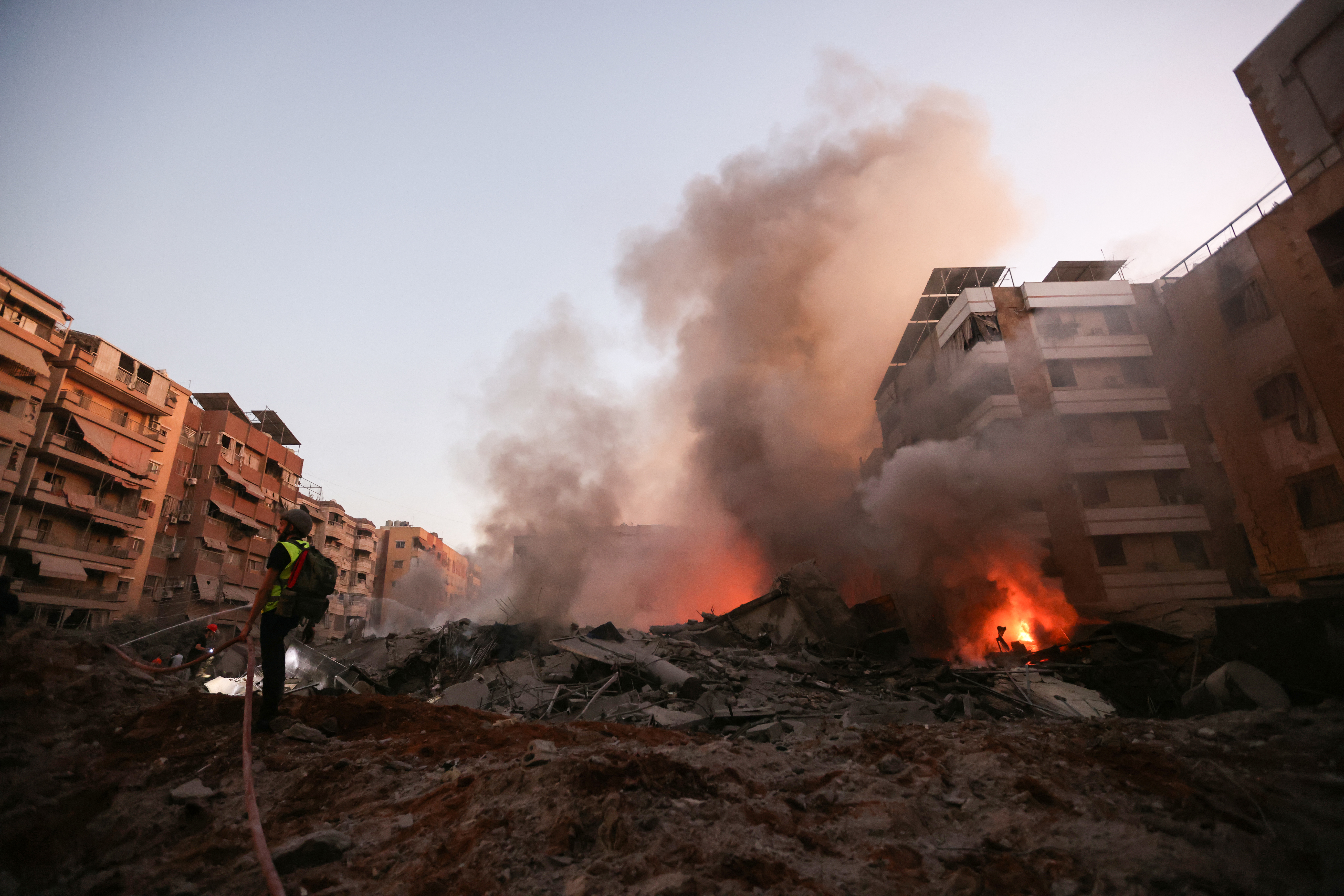 TOPSHOT - A rescuer fights the blaze amid the smouldering rubble of a building destroyed in an Israeli air strike in the Haret Hreik neighbourhood of Beirut's southern suburbs on September 27, 2024. A source close to Hezbollah said the massive Israeli strikes on Beirut's southern suburbs flattened six buildings. (Photo by Ibrahim AMRO / AFP) (Photo by IBRAHIM AMRO/AFP via Getty Images)