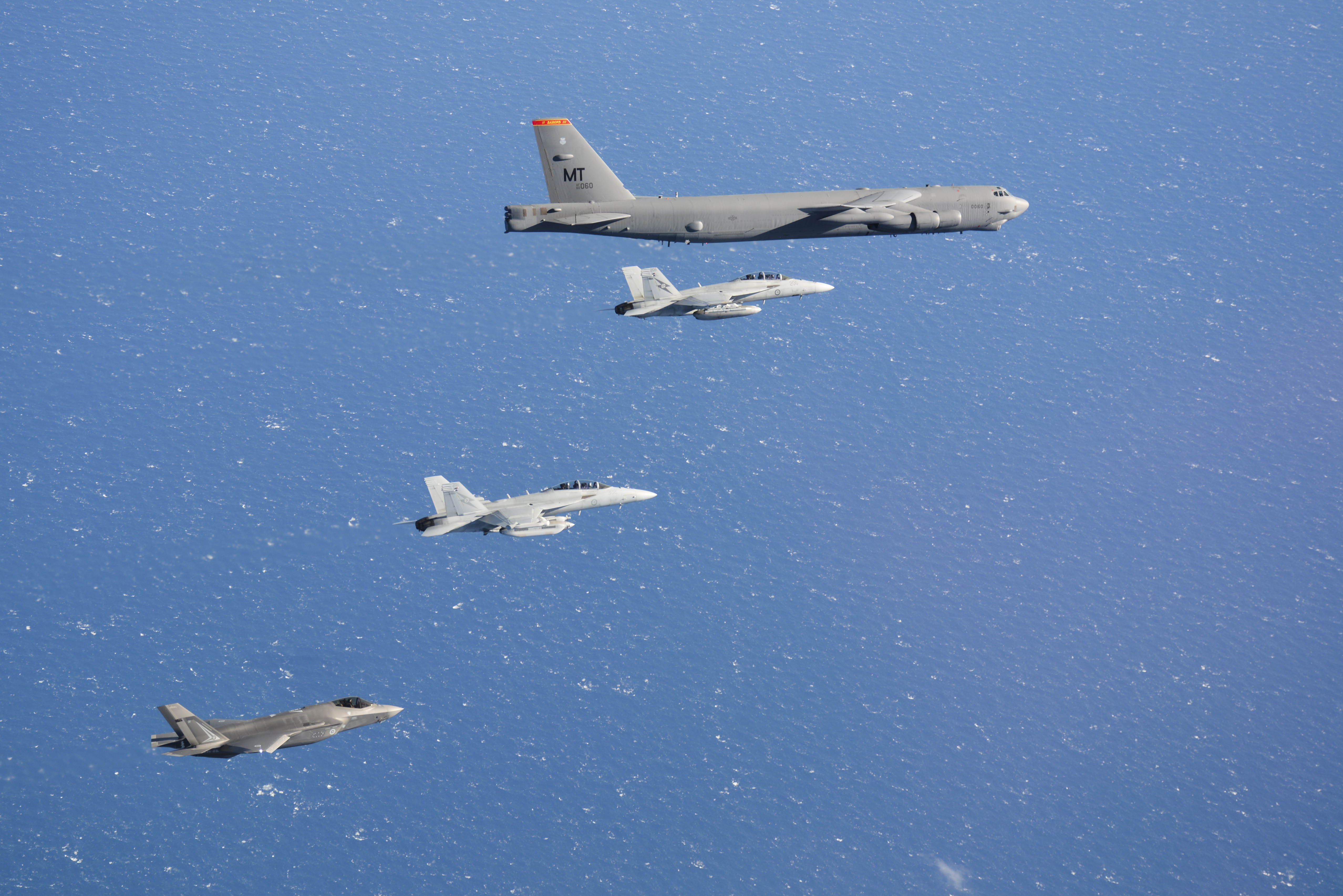 Royal Australian Air Force aircraft No.6 Squadron (Sqn) EA-18G Growler, a No.1 Sqn F/A-18F Super Hornet and an F-35A Lightning from No.3 Sqn, fly alongside a US Air Force B-52 Stratofortress from the 23rd Expeditionary Bomb Squadron based at Guam during Exercise Talisman Sabre 21. *** Local Caption *** Exercise Talisman Sabre 2021 (TS21) is the largest bilateral training activity between Australia and the United States, commencing on July 14 2021. Held every two years, TS21 aims to test Australian interoperability with the United States and other participating forces in complex warfighting scenarios. In addition to the united States, TS21 involves participating forces from Canada, Japan, Republic of Korea, New Zealand, and the United Kingdom. The exercise includes a Field Training Exercise incorporating force preparation (logistic) activities, amphibious landings, ground force manoeuvres, urban operations, air combat and maritime operations. Activities will peak from 18-31 July across Queensland. TS21 is a major undertaking for all attending nations and demonstrates the combined capability to achieve large-scale operational outcomes within a COVID-19 safe environment.