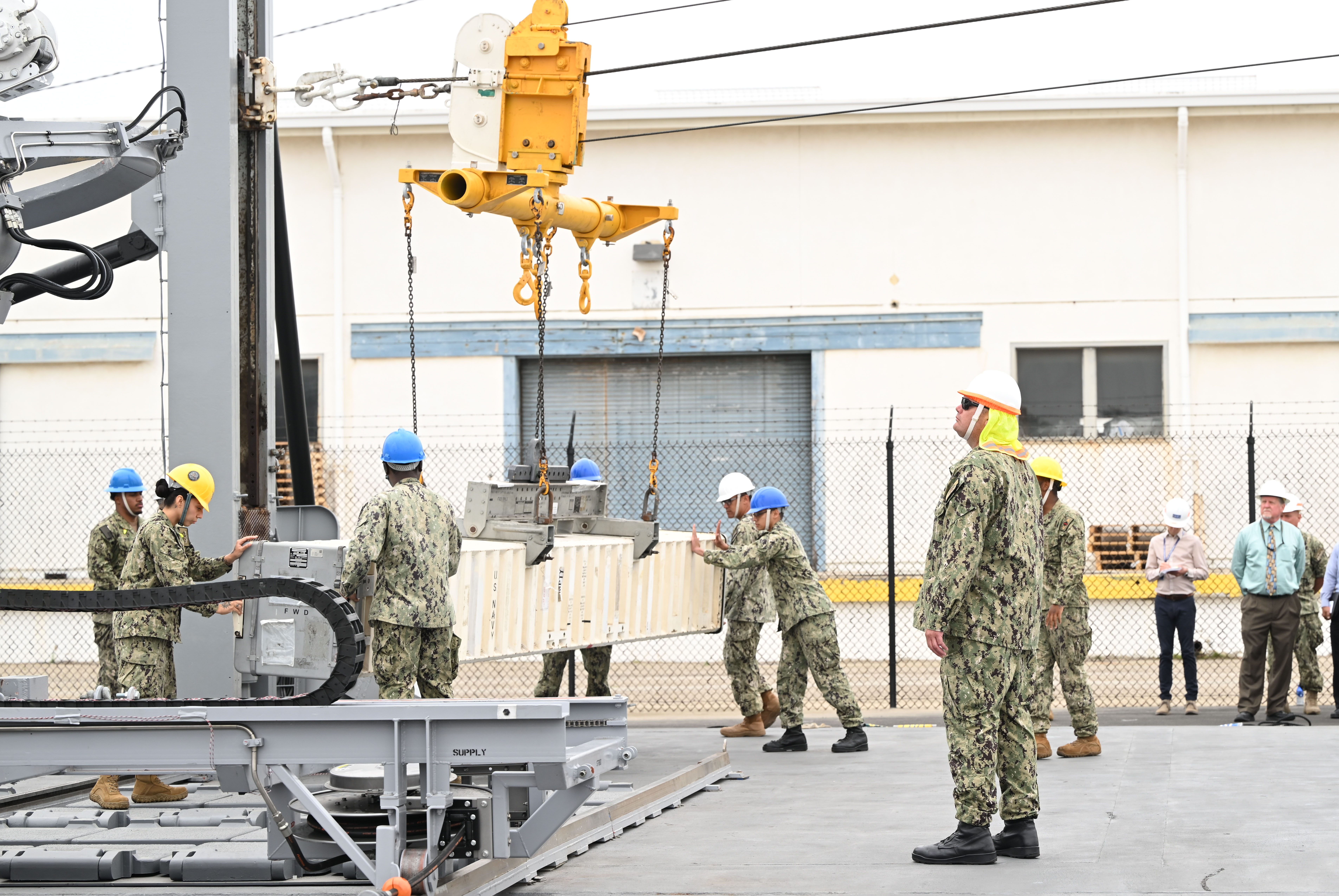 Sailors from the Naval Expeditionary Logistics Support Group and USS Chosin (CG 65) guide a missile canister using the U.S. Navy’s Transferrable Rearming Mechanism as they demonstrate the ability to reload a Vertical Launching System cell on July 11 at Naval Surface Warfare Center, Port Hueneme Division’s Underway Replenishment Test Facility. (U.S. Navy photo/released)