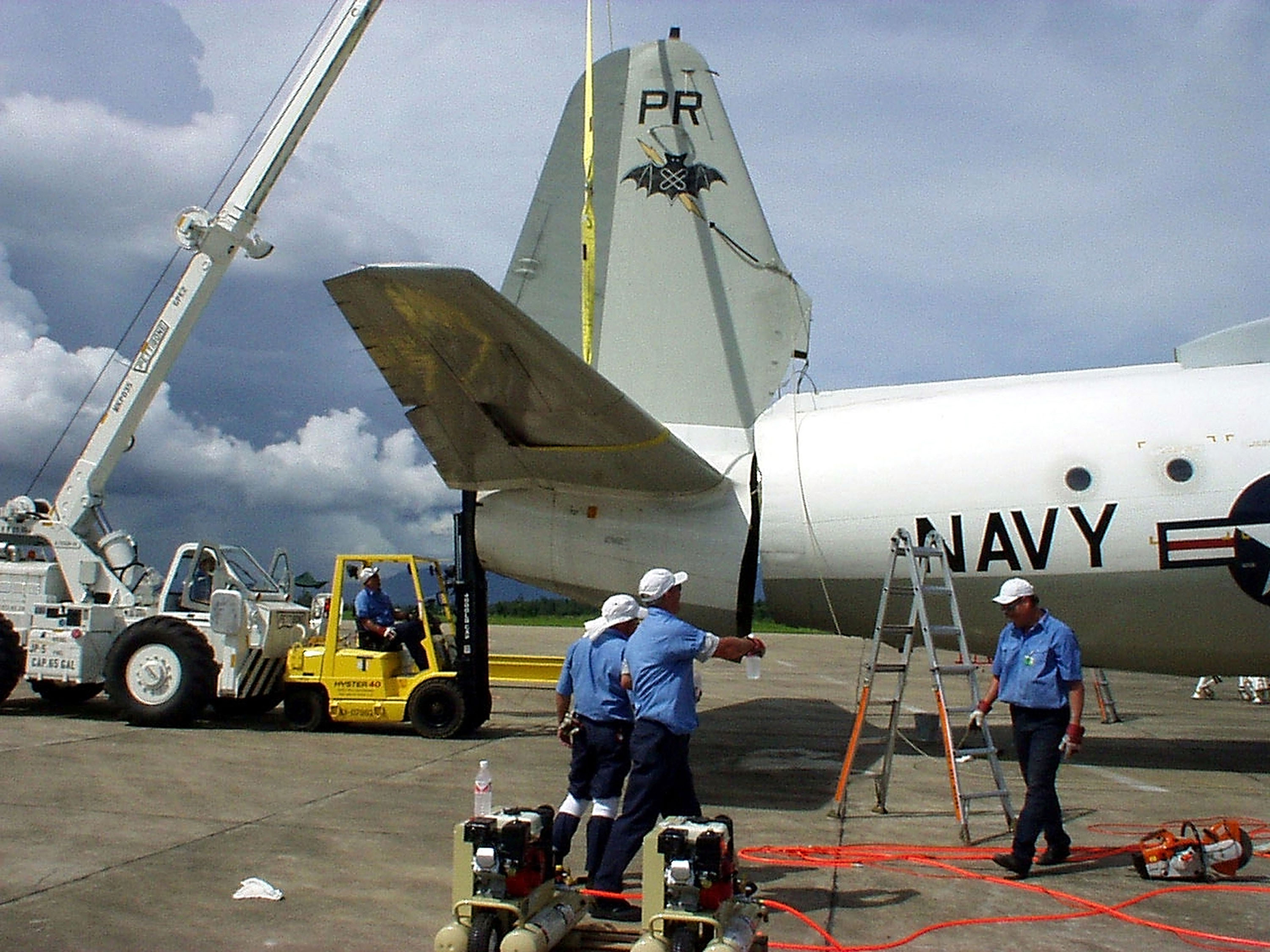 391072 04: Lockheed Martin Aeronautics Co. recovery team members steady the U.S. Navy EP-3E "Aries II" tail cone following its removal from the fuselage during disassembly work on the aircraft at Lingshui Airfield June 22, 2001 in Hainan, China. The Fleet Reconnaissance Squadron One (VQ-1) aircraft was involved in a mid-air collision with a Chinese F-8 fighter/interceptor April 1, 2001 and made an emergency landing on Hainan Island, where it has remained until disassembly and removal operations began by Lockheed Martin personnel on June 13. The aircraft will be disassembled and returned to the United States. (Photos Courtesy of Lockheed Martin Aeronautics Co./US Navy via Getty Images)