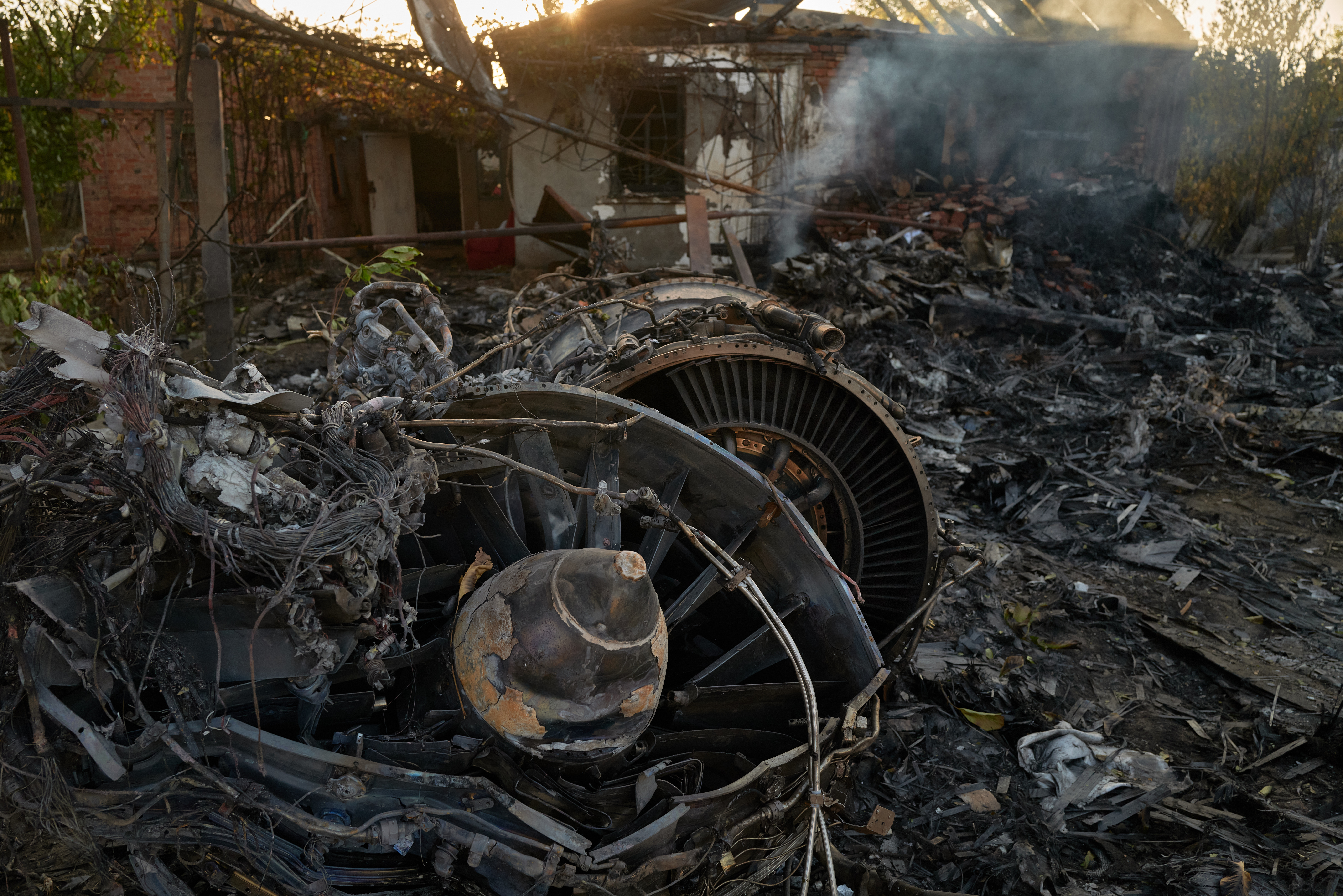 KOSTYANTYNIVKA, UKRAINE - OCTOBER 5: Ukrainian servicemen examine the wreckage of a downed Russian aircraft, likely a Sukhoi S-70 "stealth" heavy unmanned combat aerial vehicle (UCAV), which crashed in a residential area, setting a house on fire on October 5, 2024 in Kostyantynivka, Ukraine. (Photo by Pierre Crom/Getty Images)