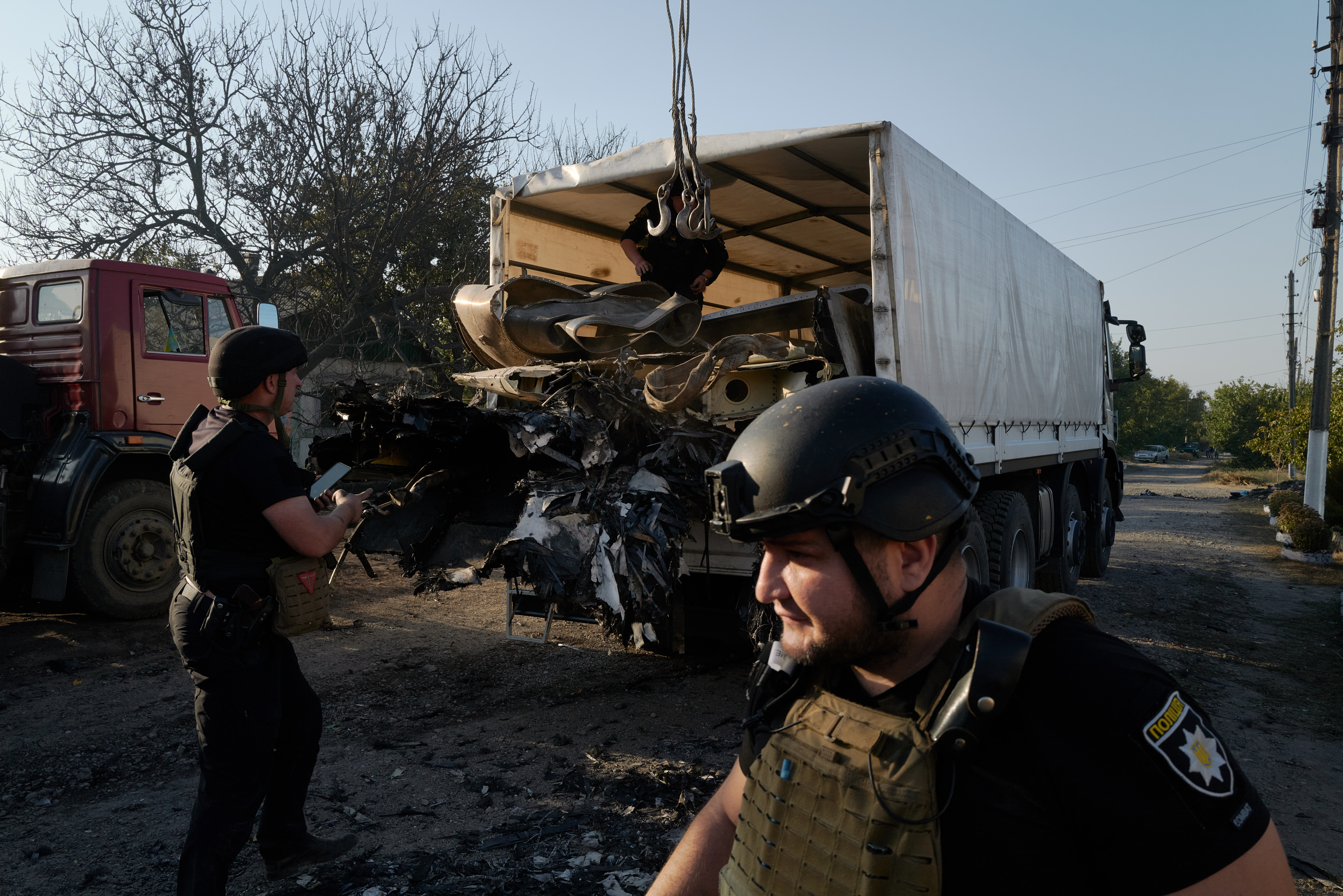 KOSTYANTYNIVKA, UKRAINE - OCTOBER 5: Ukrainian police officers recover the wreckage of a downed Russian aircraft, likely a Sukhoi S-70 "stealth" heavy unmanned combat aerial vehicle (UCAV), which crashed in a residential area, setting a house on fire on October 5, 2024 in Kostyantynivka, Ukraine. (Photo by Pierre Crom/Getty Images)