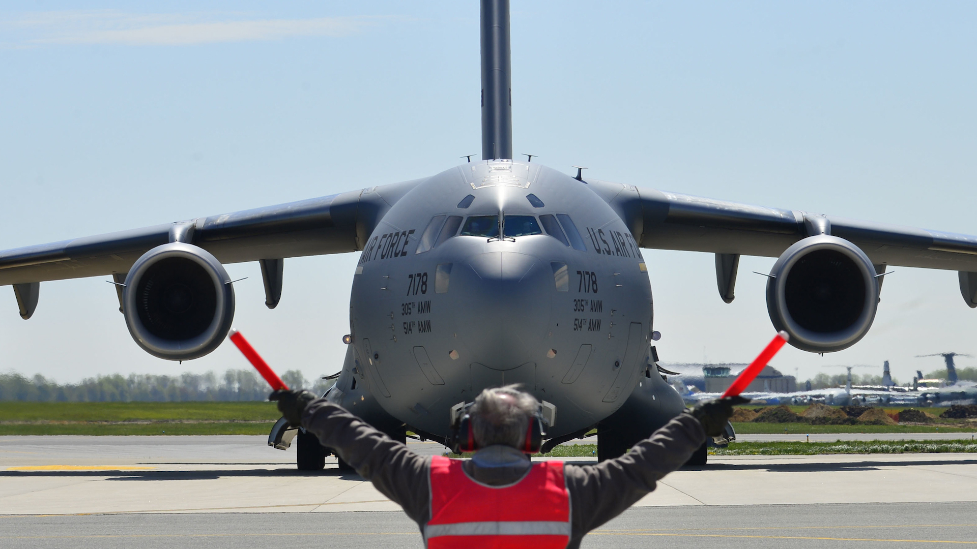 Bill Kennedy, del 436.º Escuadrón de Mantenimiento de Aeronaves en alerta de tránsito, dirige un C-17 Globemaster III de la Fuerza Aérea de los EE. UU. en la Base Aérea de Dover, Delaware, el 26 de abril de 2015. La aeronave está cargada con 69 miembros del Equipo de Búsqueda y Rescate Urbano del Condado de Fairfax, sus suministros y equipos, y seis K-9, para ayudar a Nepal con las operaciones de rescate después de que el país fuera golpeado por un terremoto de magnitud 7,8.