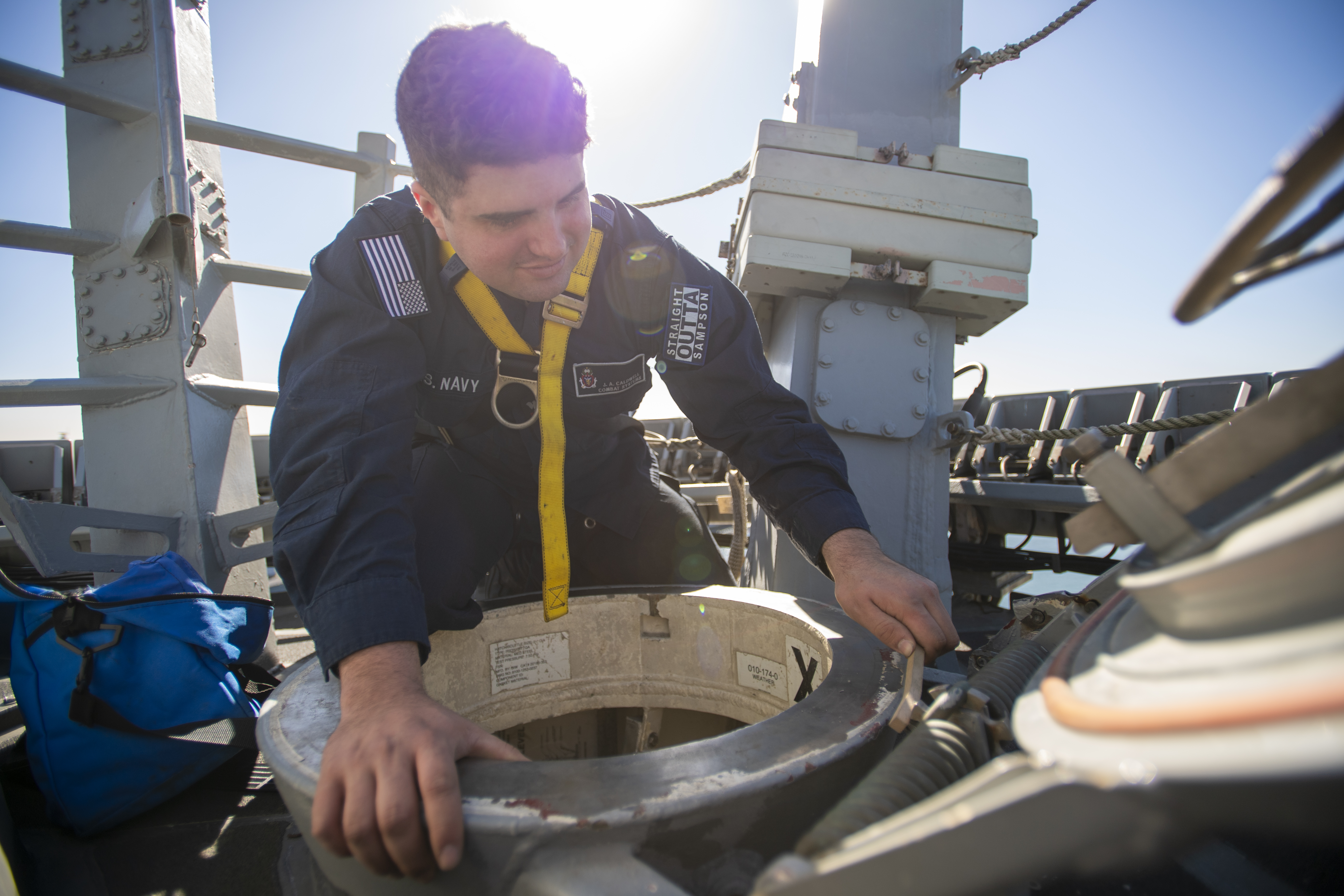 Electronics Technician 2nd Class Jarrod Caldwell, from Greensboro, North Carolina, performs corrective scuttle maintenance while working aloft on the mast of the Arleigh Burke-class guided-missile destroyer USS Sampson (DDG 102) while in port at Naval Base San Diego, Jan. 23, 2025. Sampson is in port conducting routine operations. (U.S. Navy photo by Mass Communication Specialist 2nd Class Timothy Meyer)