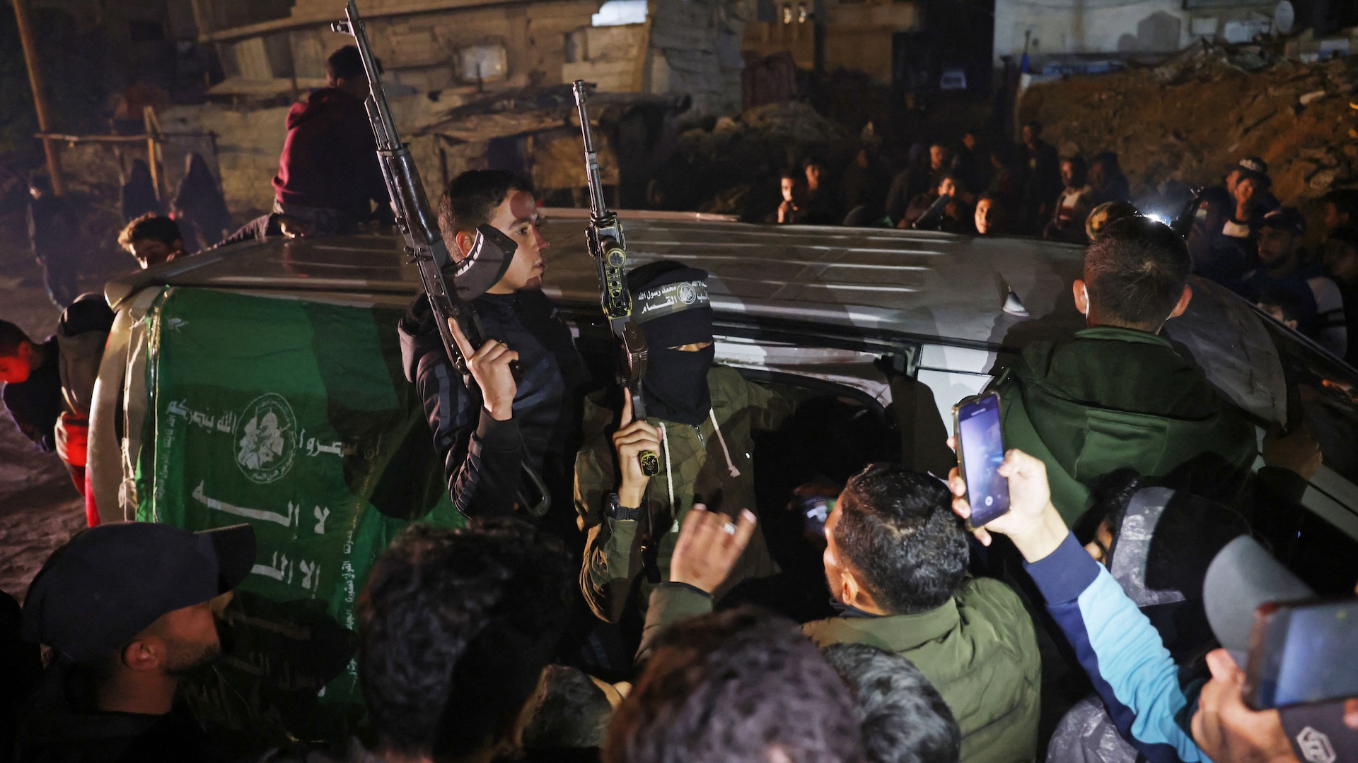 Members of Hamas's armed wing, the Ezzedine al-Qassam Brigades, arrive in a vehicle at a street in Khan Yunis in the southern Gaza Strip on January 15, 2025, amid the ongoing war in the Palestinian territory between Israel and Hamas. Thousands of Gazans celebrated on January 15 as news spread that a ceasefire and hostage release deal had been reached between Israel and Hamas, aimed at ending more than 15 months of war in the Palestinian territory.