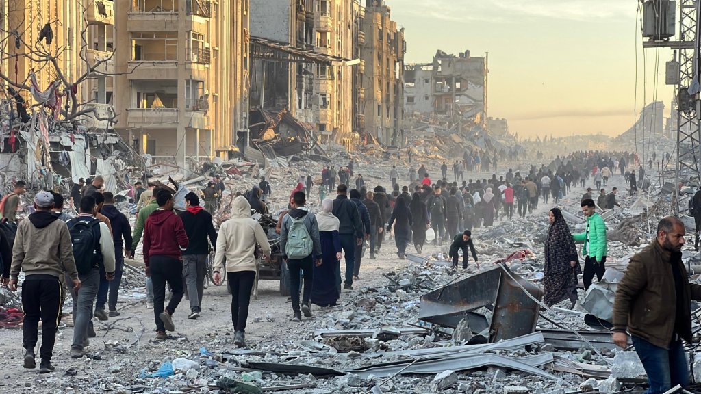 JABALIA, GAZA - JANUARY 19: Palestinians walk among the debris of destroyed buildings as they return to their homes after the announcement of the ceasefire and the hostage-prisoner exchange agreement between Hamas and Israel in Jabalia, Gaza, January 19, 2025. (Photo by Ramzi Mahmud/ Anadolu via Getty Images)