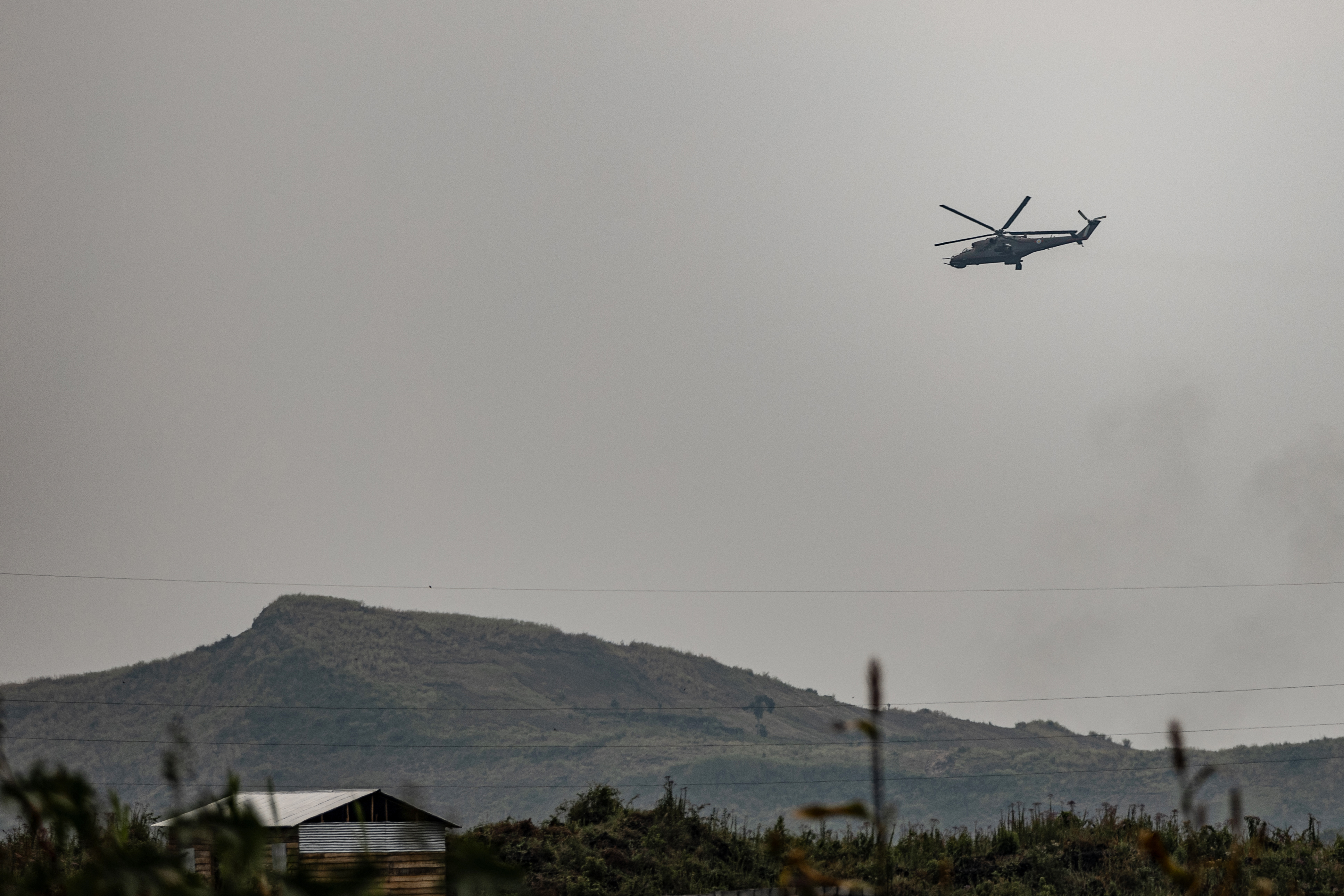 An attack helicopter of the Armed Forces of the Democratic Republic of Congo (FARDC) flies along the road leading to the entrance of the town of Sake, 25km north-west of Goma, on January 23, 2025. The M23 armed group has seized further territory in the east of the Democratic Republic of Congo and on Thursday was continuing to tighten its grip on provincial capital Goma, which is almost surrounded by fighting. (Photo by Michael Lunanga / AFP) (Photo by MICHAEL LUNANGA/AFP via Getty Images)