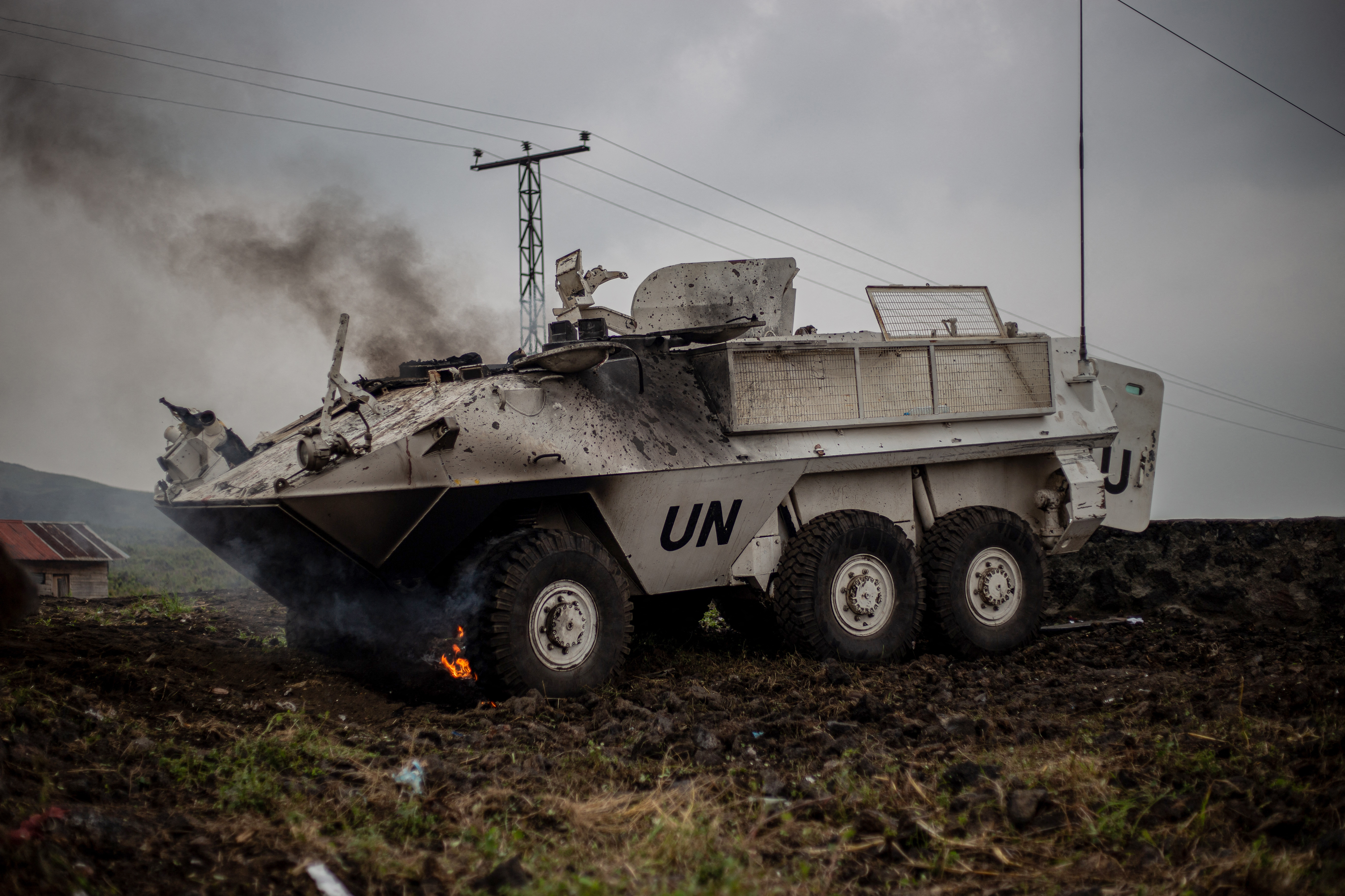 TOPSHOT - Smoke billows from an armored personnel carrier (APC) of the United Nations Organization Stabilization Mission in the Democratic Republic of the Congo (MONUSCO) left on the side of the road in Nzulo, on the main road linking the North Kivu capital Goma to the town of Sake, on January 25, 2025. Three South African soldiers were killed and 18 injured in clashes with M23 forces in the east of the Democratic Republic of Congo, where they were part of a southern African mission, a political party and a military union said Saturday. (Photo by Jospin Mwisha / AFP) (Photo by JOSPIN MWISHA/AFP via Getty Images)