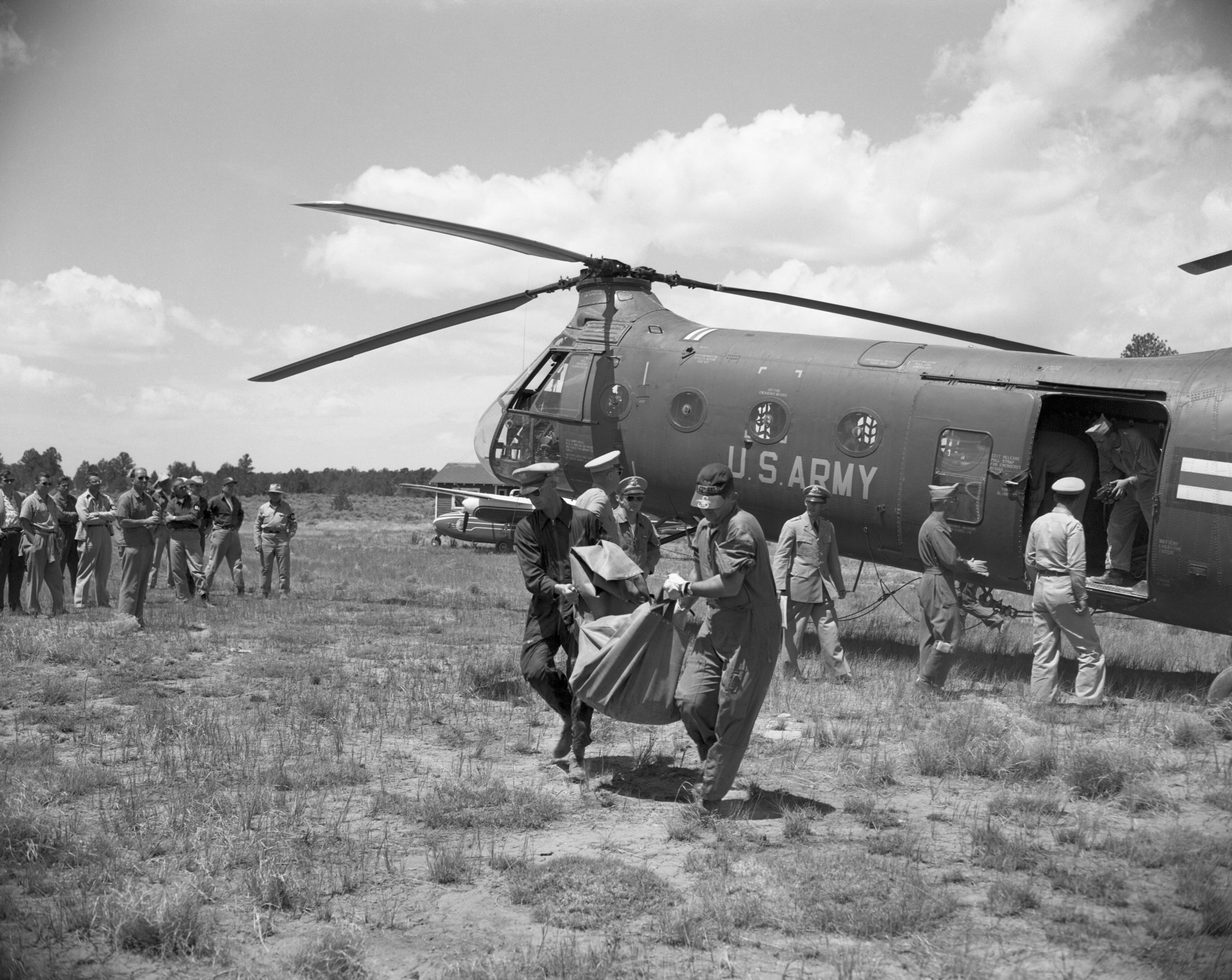 Bodies taken from the wreckage of Ual plane are removed from helicopter which recovered them from the Grand Canyon where the plane and a TWA Super Constellation crashed on June 29th. The helicopter flew the bodies from the Canyon floor to the Grand Canyon airport where they were transshipped to Flagstaff, Arizona.