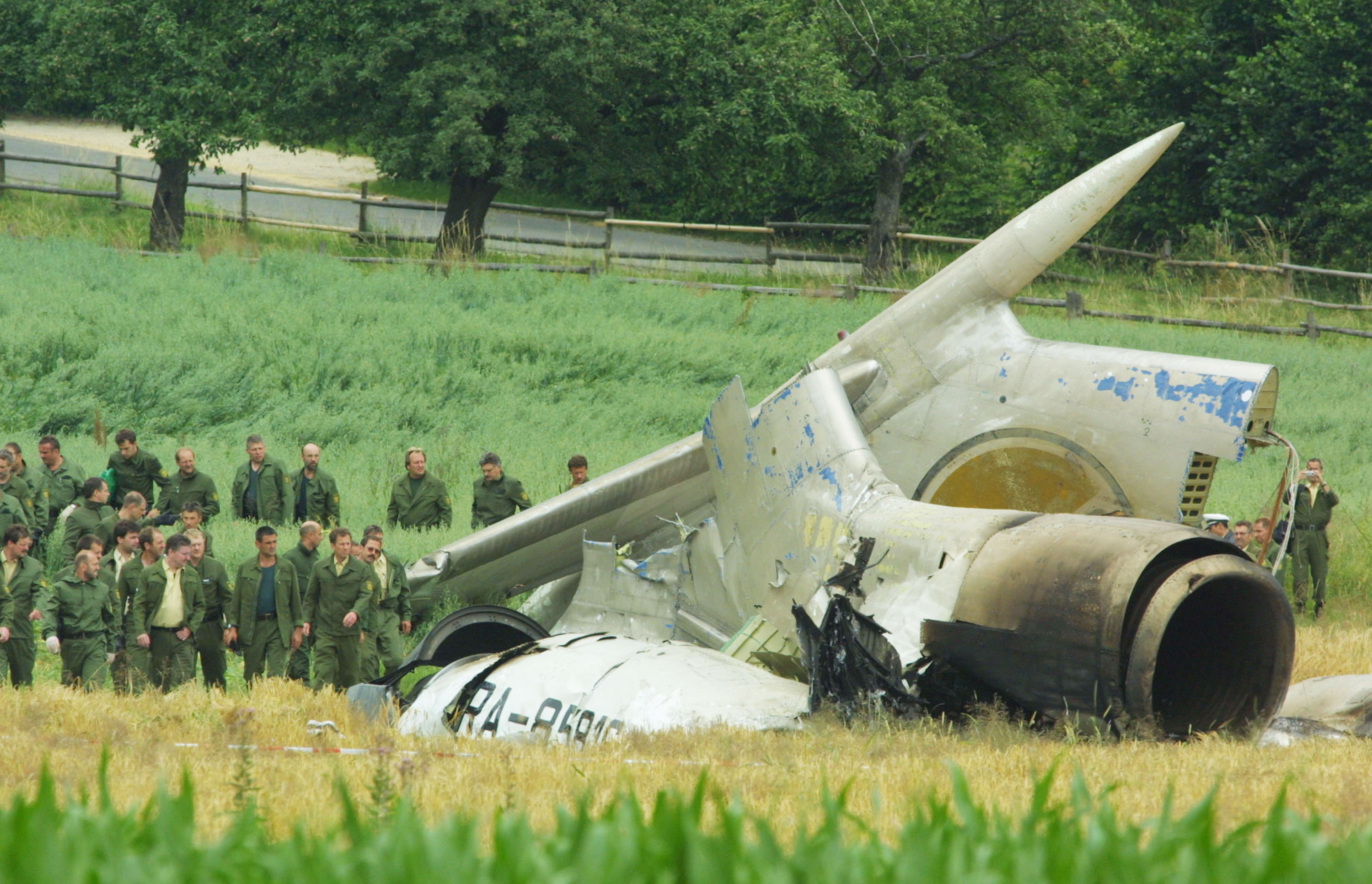 UEBERLINGEN, GERMANY - JULY 2: German police walk by the tail wreckage of a Tupelov-154 Russian passenger airliner July 2, 2002 near the town of Ueberlingen, Germany. The aircraft collided with a DHL cargo plane during the night and at least 71 people, including 52 children and teenagers, are feared dead. (Photo by Sean Gallup/Getty Images)