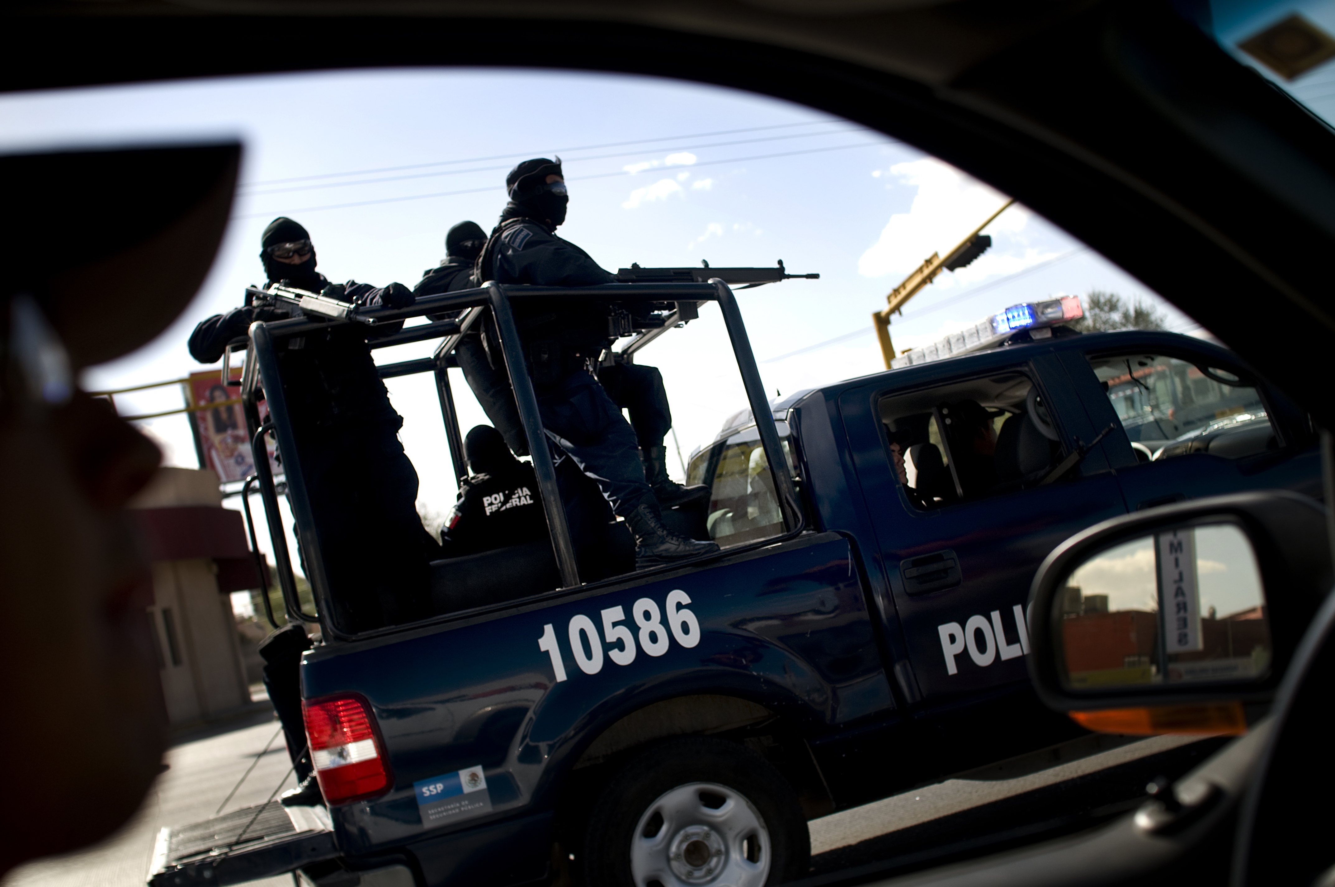 JUAREZ, MEXICO - NOVEMBER 10: Federalis (Federal Police) search cars at a impromptu checkpoint near the border in Juarez. Frequently Army and Police forces take such measures in attempt to catch drug traffickers. The border city of Juarez (population: 1.5 million) is a slaughterhouse ruled by drug lords where the death toll this year is 1,300 and counting. (Photo by Shaul Schwarz/Edit by Getty Images)