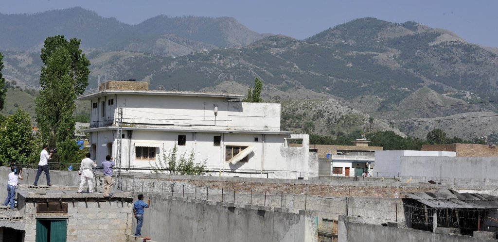 Pakistani media personnel film the building which was used as the hideout by Al-Qaeda leader Osama bin Laden following his death by US Special Forces in a ground operation in Abbottabad on May 3, 2011. The bullet-riddled Pakistani villa that hid Osama bin Laden from the world was put under police control, as media sought to glimpse the debris left by the US raid that killed him. Bin Laden's hideout had been kept under tight army control after the dramatic raid by US special forces late May 1 in the affluent suburbs of Abbottabad, a garrison city 50 kilometres (30 miles) north of Islamabad. AFP PHOTO/ AAMIR QURESHI (Photo credit should read AAMIR QURESHI/AFP via Getty Images)