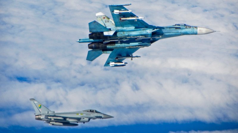 A Russian SU-27 Flanker aircraft banks away with a RAF Typhoon in the background. RAF Typhoons were scrambled on Tuesday 17 June 2014 to intercept multiple Russian aircraft as part of NATO’s ongoing mission to police Baltic airspace. The Typhoon aircraft, from 3 (Fighter) Squadron, were launched after four separate groups of aircraft were detected by NATO air defences in international airspace near to the Baltic States. Once airborne, the British jets identified the aircraft as a Russian Tupolev Tu22 ‘Backfire’ bomber, four Sukhoi Su27 ‘Flanker’ fighters, one Beriev A50 ‘Mainstay’ early warning aircraft and an Antonov An26 ‘Curl’ transport aircraft who appeared to be carrying out a variety of routine training. The Russian aircraft were monitored by the RAF Typhoons and escorted on their way. The Typhoon pilots involved in the operation were Flight Lieutenant (Flt Lt) Mark Long of 29 (Reserve) Squadron (the Typhoon operational training unit) and a French Air Force exchange pilot Commandant Marc-antoine Gerrard who is currently attached to 1(Fighter) Squadron.