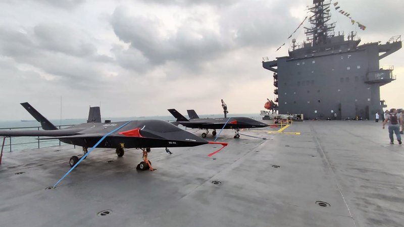 Iran has finally shown a drone taking off and landing on – in the latter case with the help of arresting gear – the deck of the country's unusual new 'drone carrier,' the Shahid Bagheri. Newly emerged imagery also shows various drones and crewed helicopters on the flight deck, which has a ski jump at the bow end, including the appearance of 'drones' styled after the infamous Qaher 313.