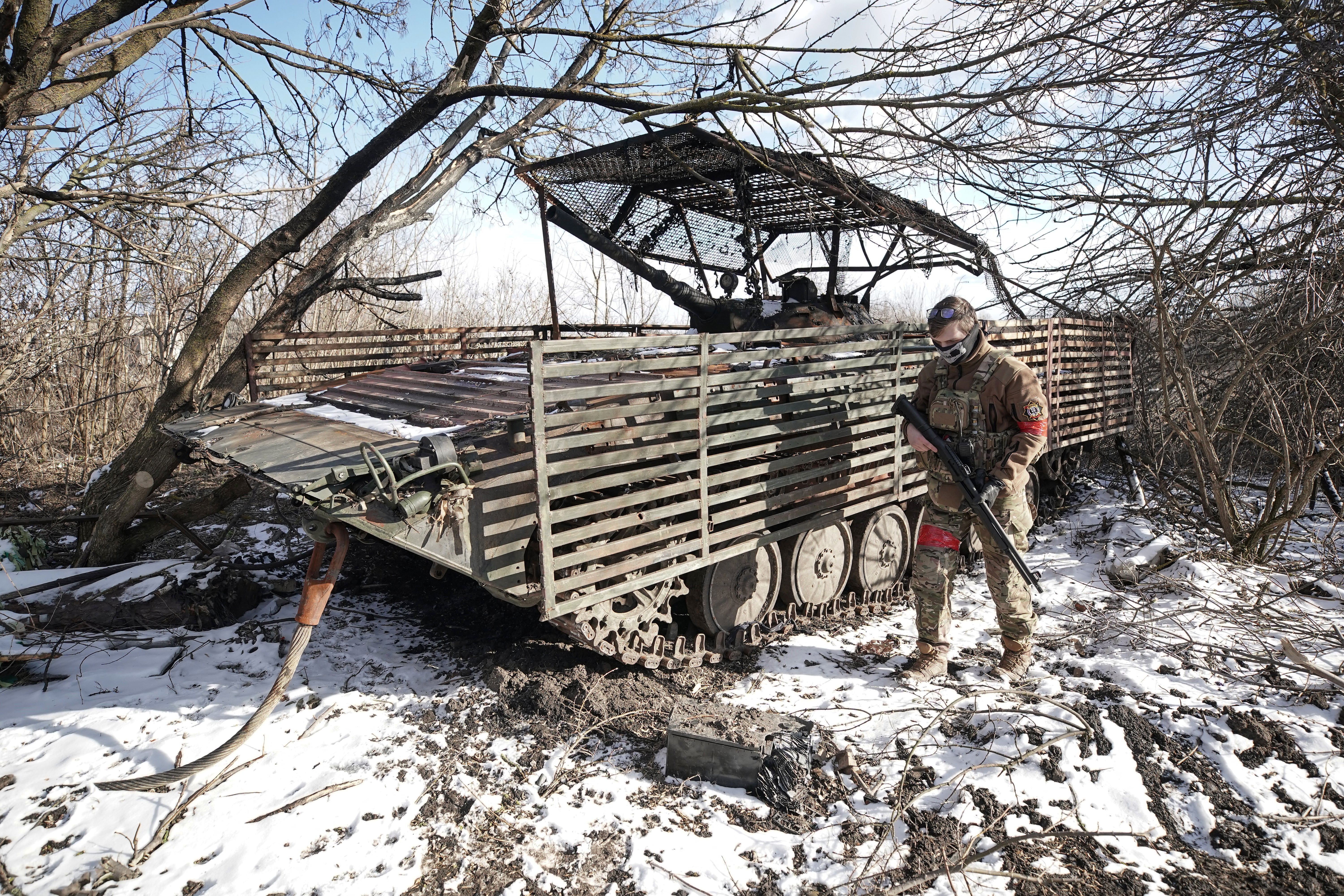 A 24-year-old radio operator of the Chechen Akhmat battalion with the call sign "Swallow" stands by a burned out Ukrainian infantry fighting vehicle in the village of Kazachya Loknya, which was previously held by Ukrainian troops and recently retaken by Russia's armed forces, in the Sudzha district of the Kursk region on March 18, 2025, amid the ongoing Russian-Ukrainian conflict. (Photo by TATYANA MAKEYEVA / AFP) (Photo by TATYANA MAKEYEVA/AFP via Getty Images)