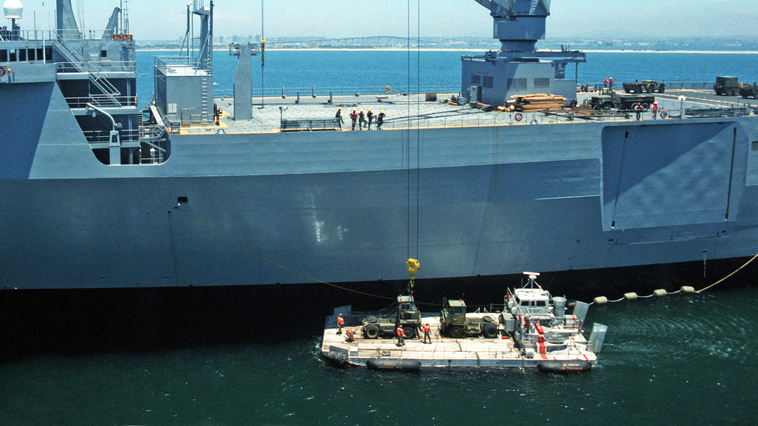 message-editor%2F1632403314187-croppedcranes_aboard_the_vehicle_cargo_ship_usns_altair_t-akr-291_lower_equipment_to_a_landing_craft_on_15_july_1986.jpg